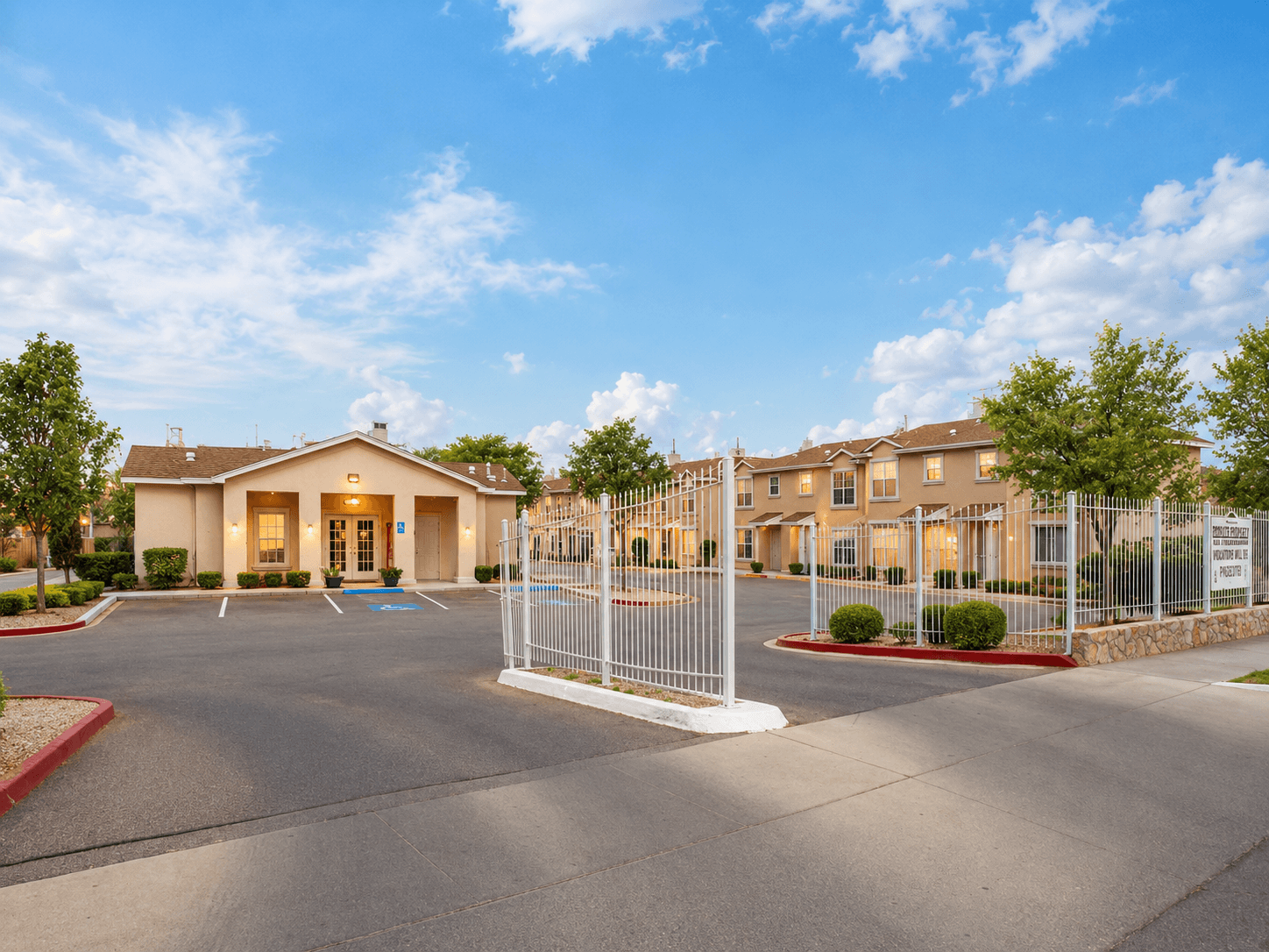A gated community with a large building in the background.